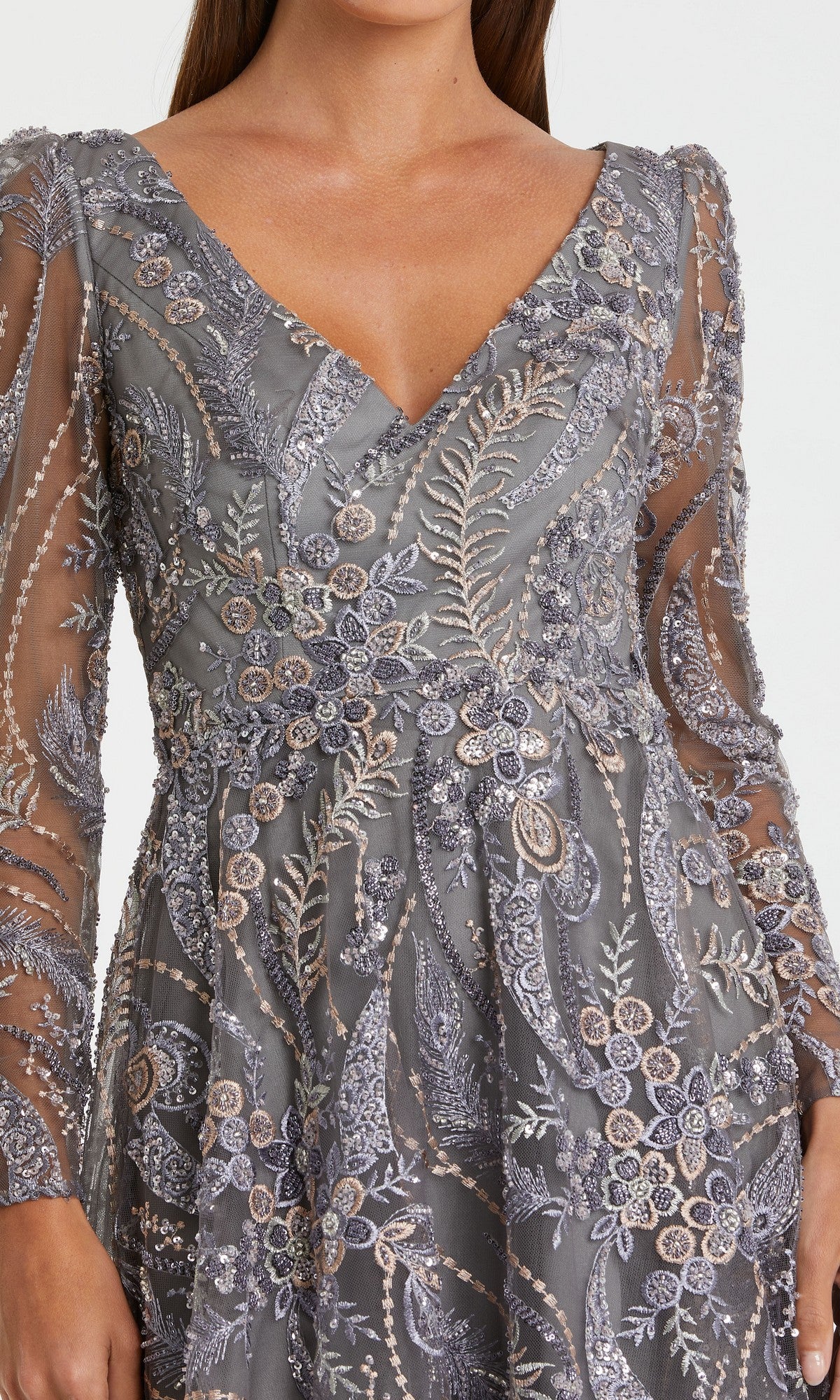 A woman wearing the Midi Party Dress: Mac Duggal 68913 in silver and lavender, featuring sheer long sleeves and exquisite floral detailing, photographed from shoulders to waist.
